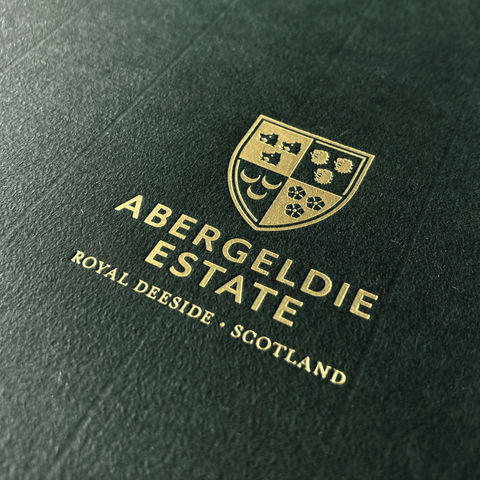 Gold foil logo featuring the Abergeldie Estate shield on premium dark green stock.