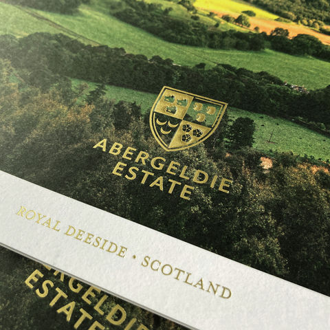 Abergeldie Estate brochure with gold foil logo featuring the estate’s landscape.
